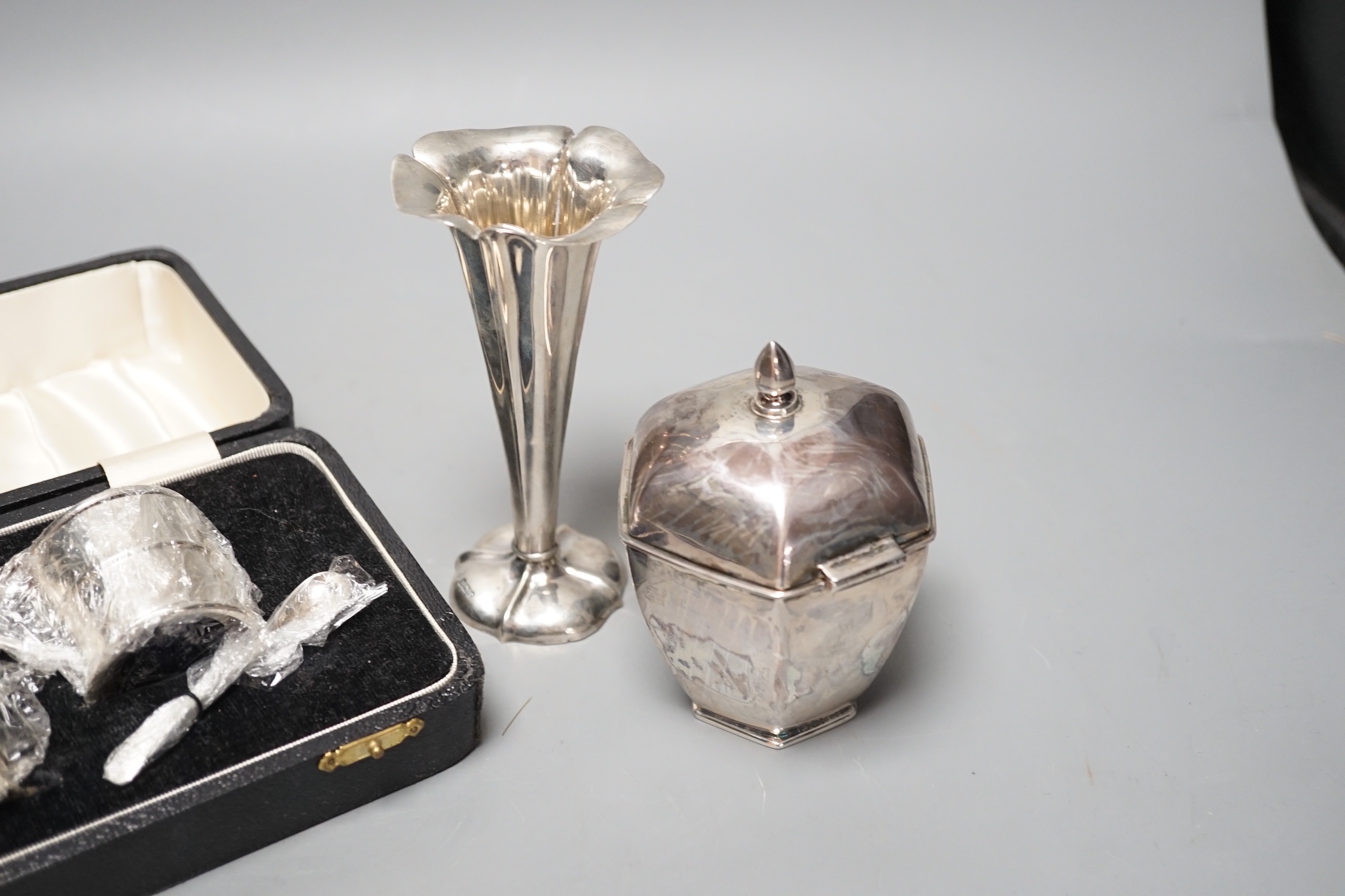 A George V silver hexagonal tea caddy, Sheffield, 1919, 10.5cm, a silver posy vase and a cased three piece silver condiment set.